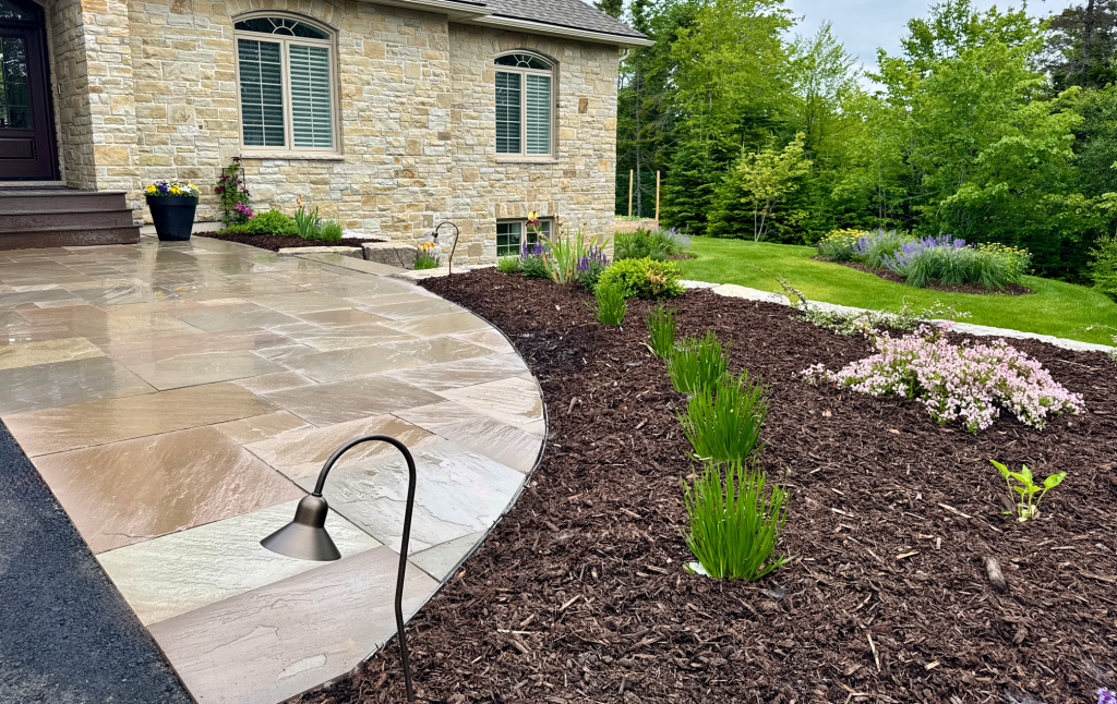 stonework patio and a freshly planted garden